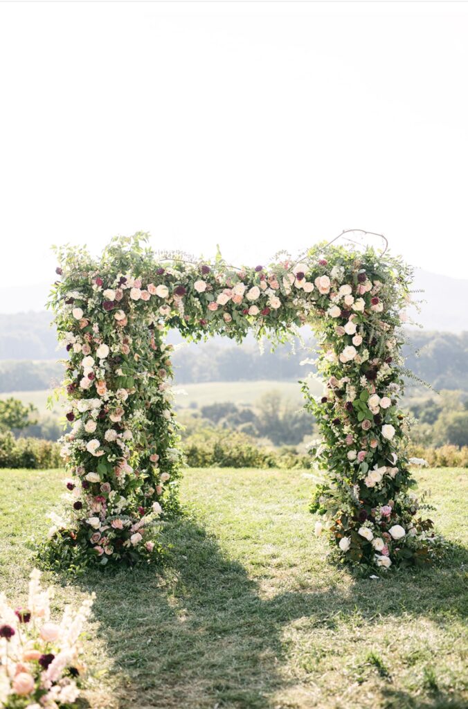 Summer Bride Pippin Hill Farm Wedding Ceremony Chuppah filled with flowers in a color palette of blush, purple and burgundy.